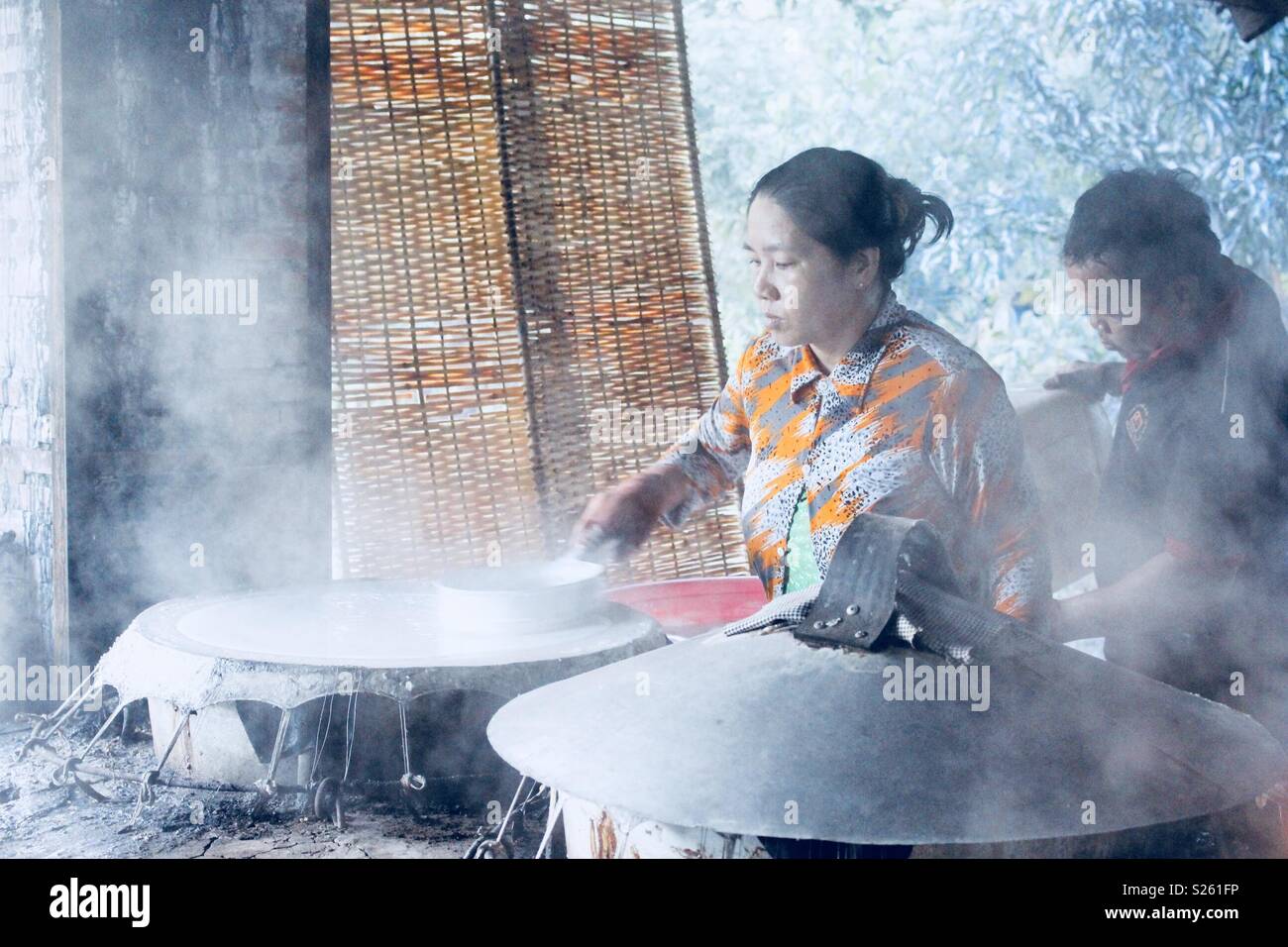 Vietnamese woman making rice paper in a rice paper factory Stock Photo