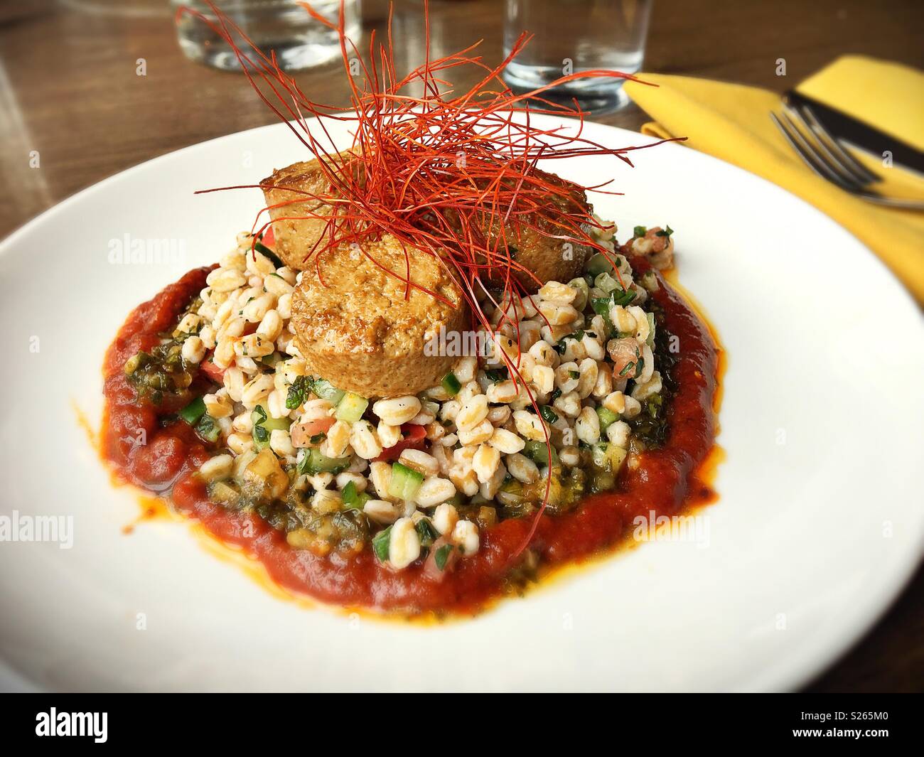 Pan seared tofu with tabbouleh and roasted tomato harissa, a vegan meal from Fig and Farro in Minneapolis, MN, USA. Stock Photo
