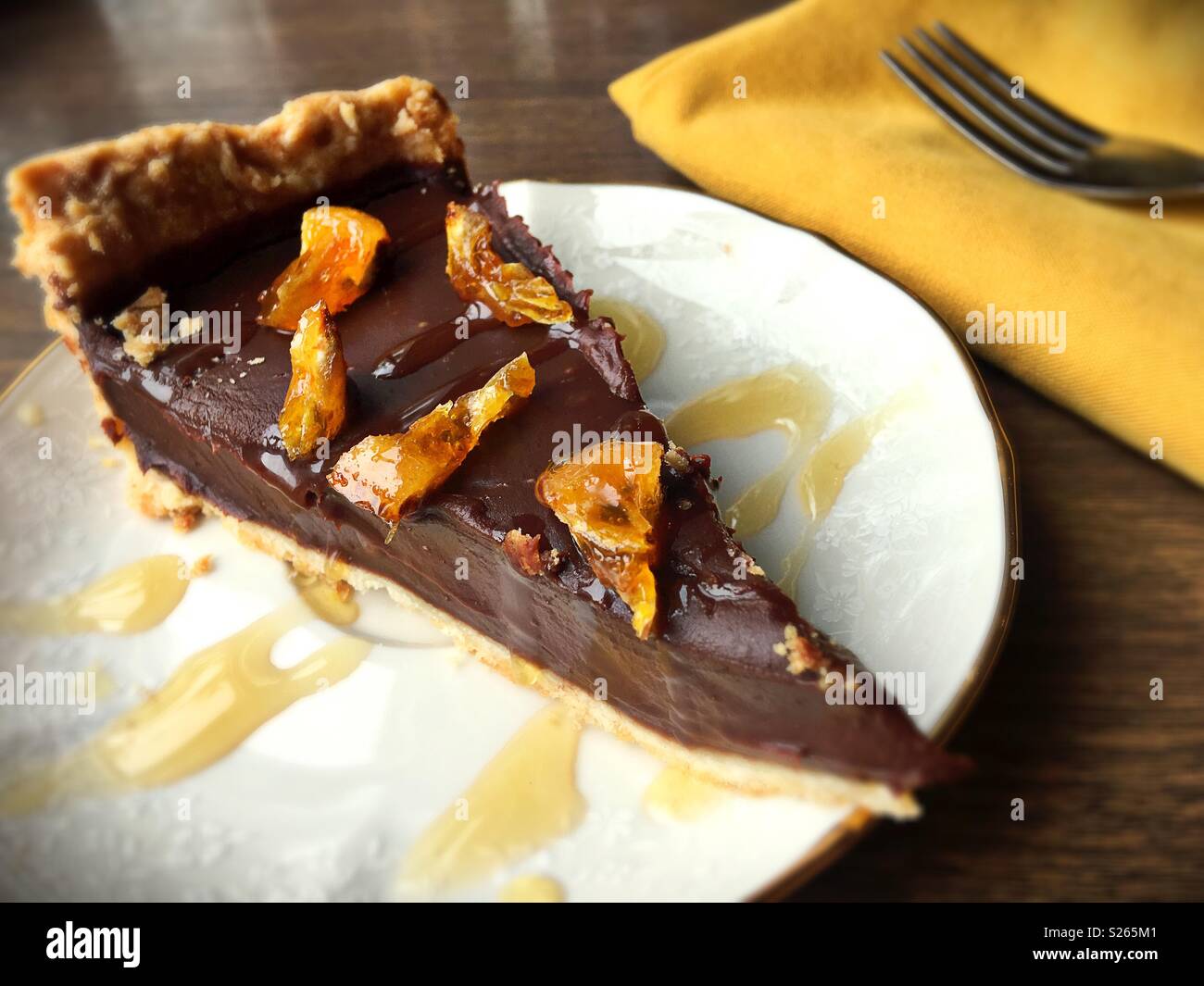 A slice of vegan dark chocolate pie topped with candied orange. Stock Photo