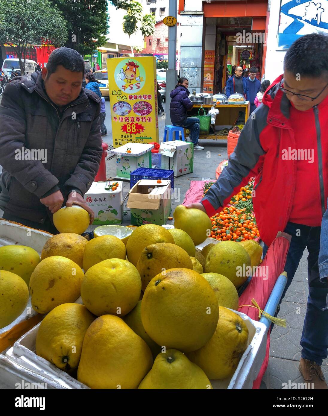 Buying pomelos from a street vendor in Shaoguan, China. - Smartphone Captured Stock Image