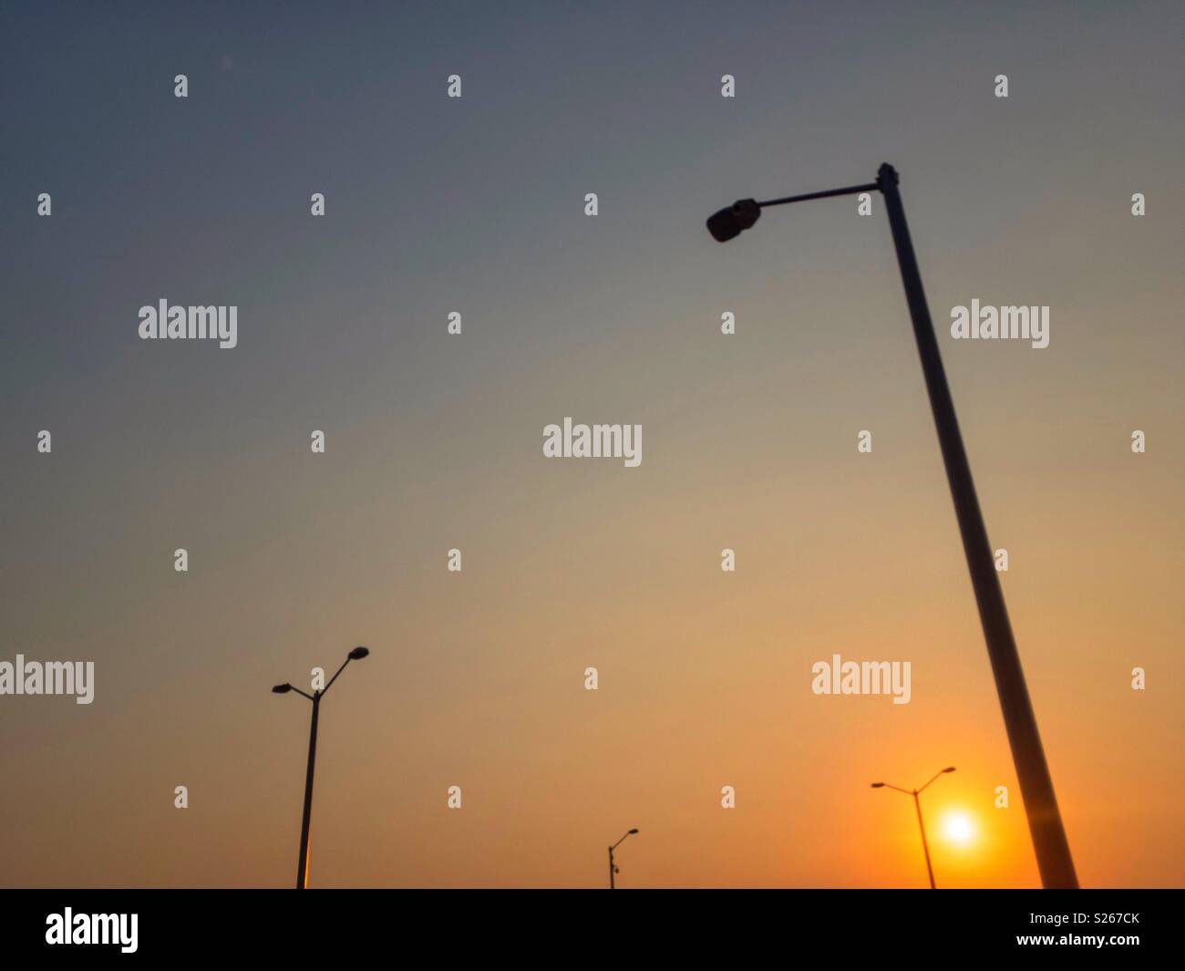 Sunrise and lampposts silhouettes. Stock Photo