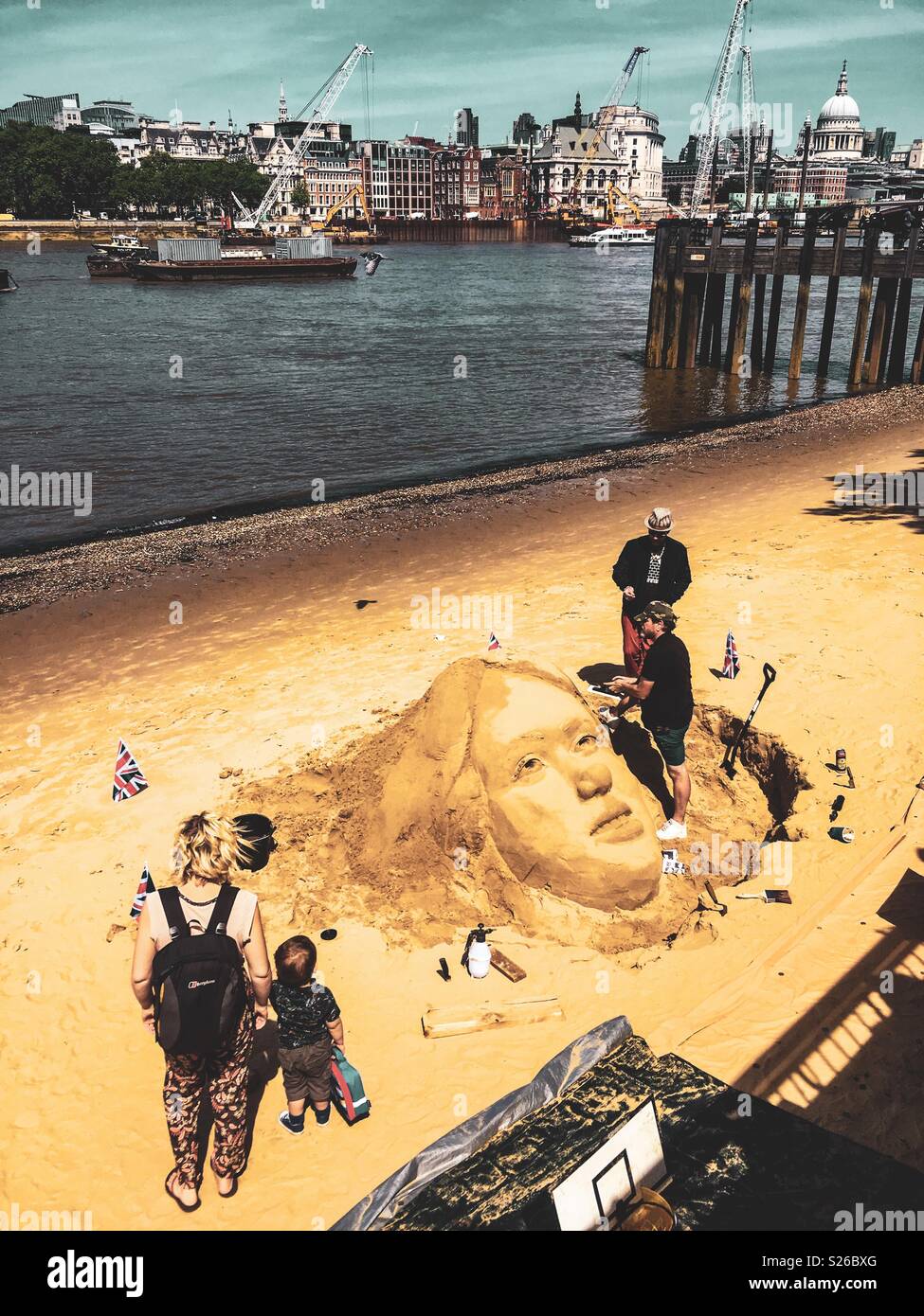 Artist making a sculpture out of sand in London - Smartphone Captured Stock Image