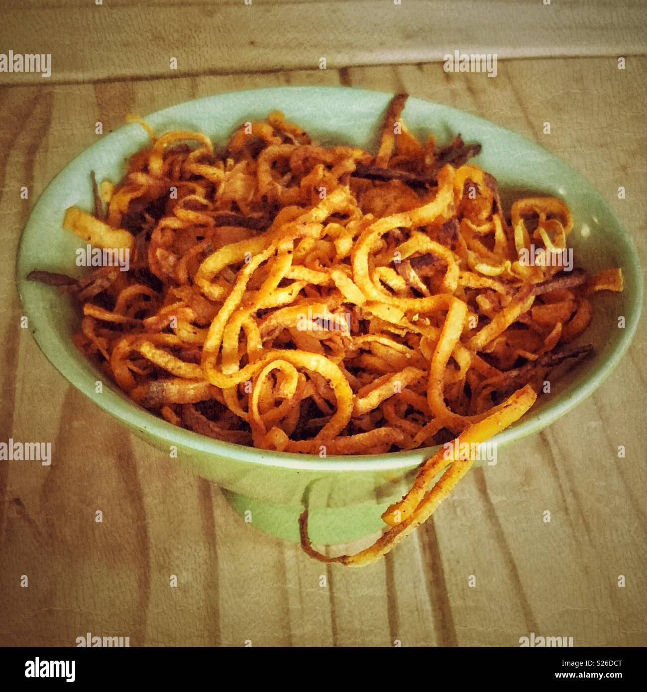 Green bowl full of fresh made spiralized sweet potato noodles - Smartphone Captured Stock Image