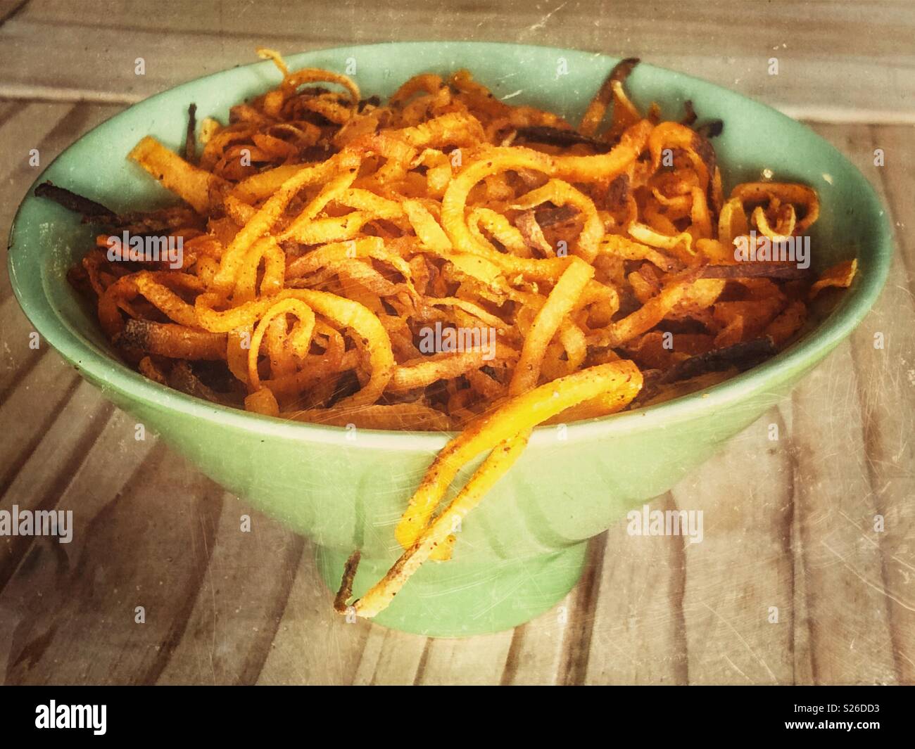 Green bowl full of fresh made spiralized sweet potato noodles - Smartphone Captured Stock Image