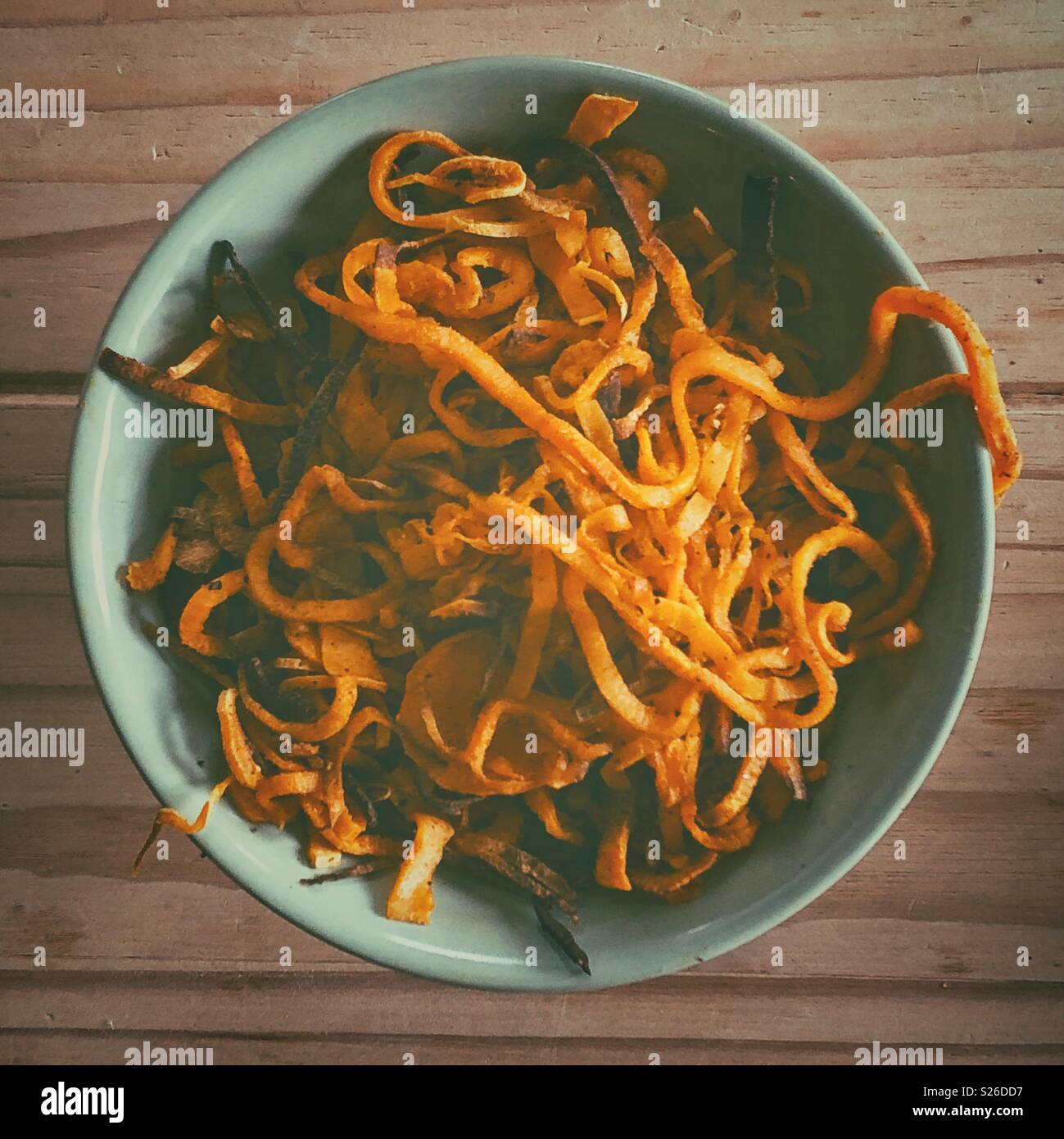 Flat lay view of green bowl full of spiralized sweet potato vegetable noodles - Smartphone Captured Stock Image
