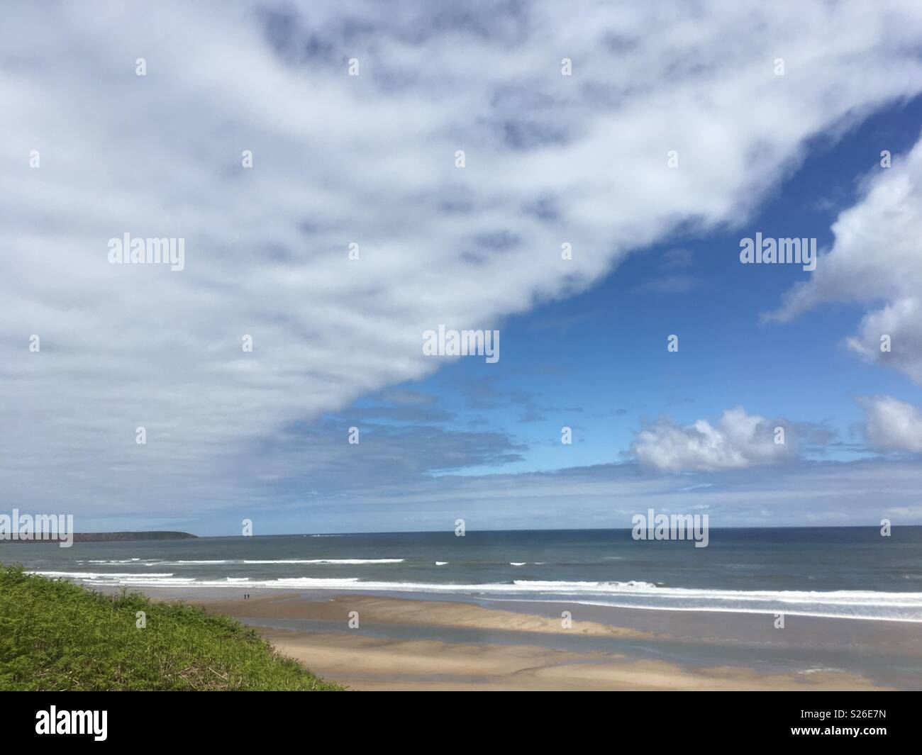 Beach walk on a summer day. Clouds are clearing and the sky is becoming blue. Huge wide bay where you can walk to clear your head and be at one with nature. Perspective gained in an hour. Stock Photo