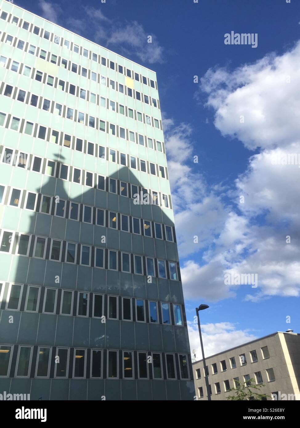 Shadow of an old building cast on a newer one. Seen whilst out walking in Oslo, Norway. - Smartphone Captured Stock Image