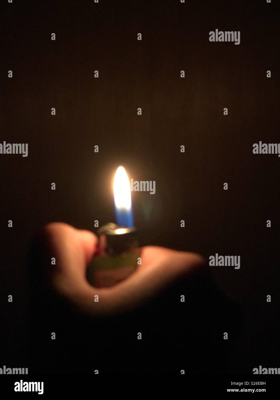 Lighter in a dark room Stock Photo