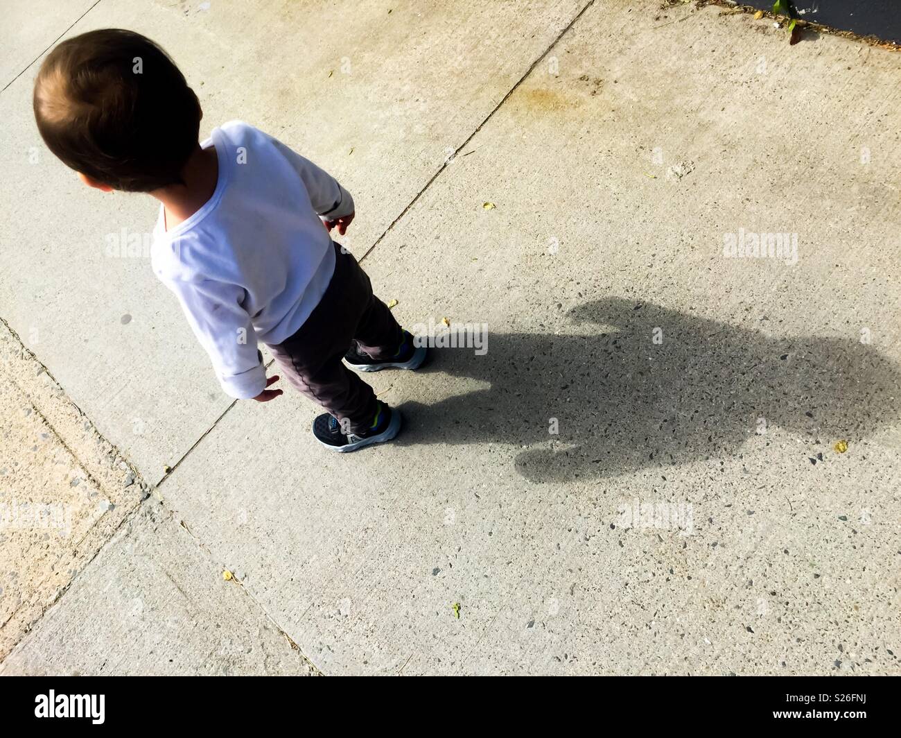 Toddler and his shadow behind him, Nova Scotia, Canada. Where am I? - Smartphone Captured Stock Image