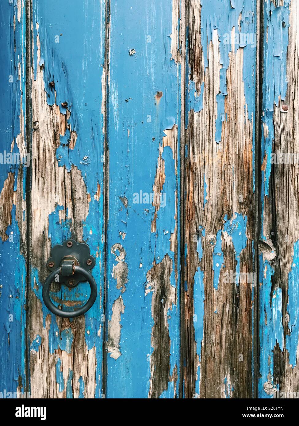 Flaking blue paint on an old wooden door. Stock Photo