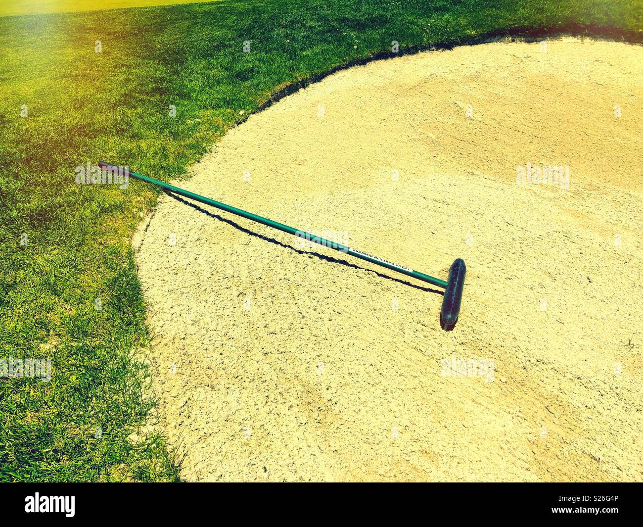 Greenside bunker rake straddles sand trap on a Northern California golf course. - Smartphone Captured Stock Image