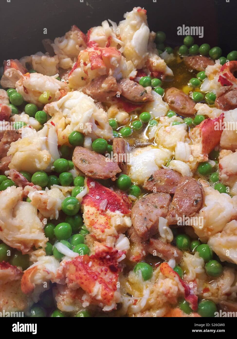 Gourmet lobster fettuccine dish with spring peas and sausage. - Smartphone Captured Stock Image