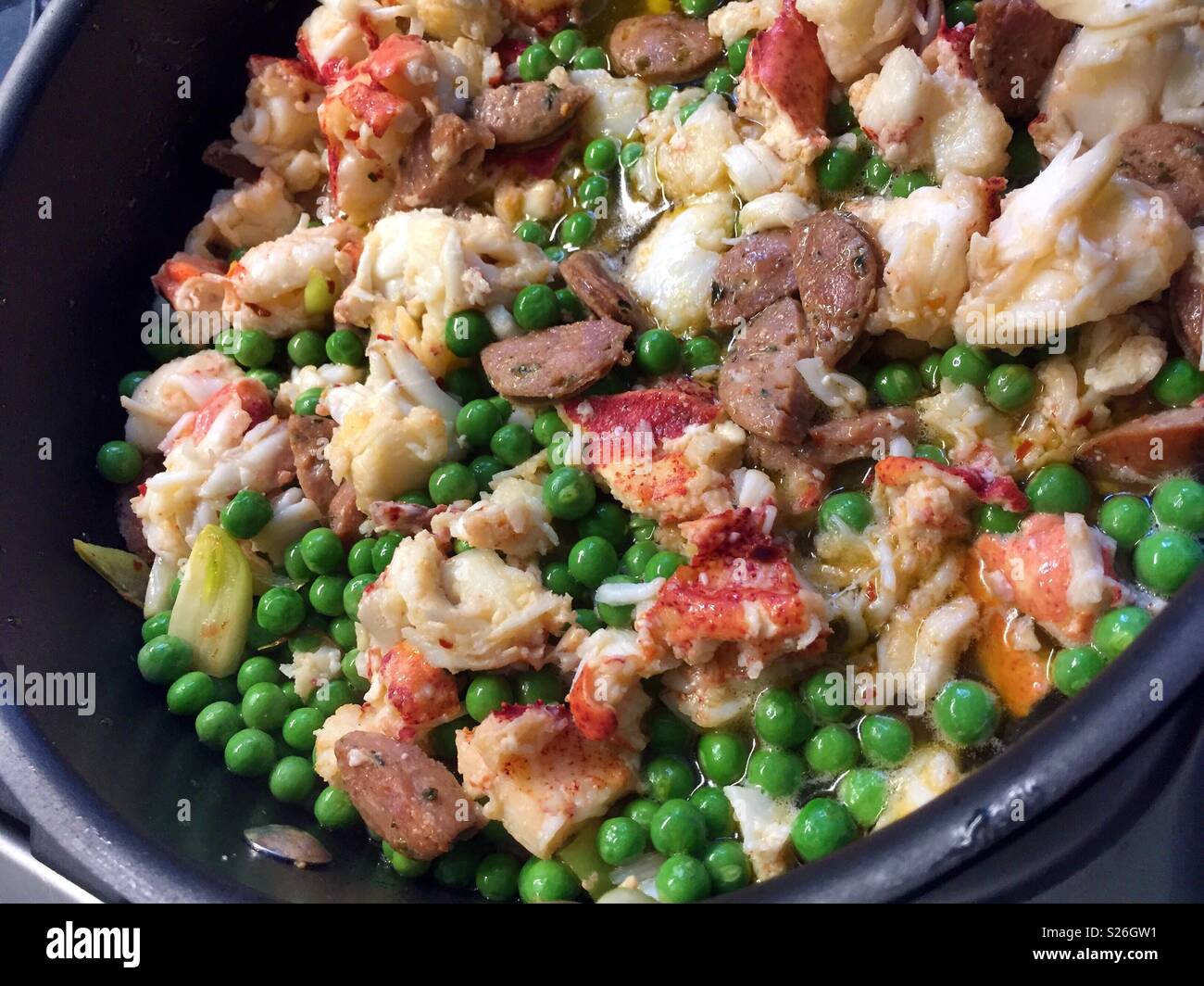 Gourmet lobster fettuccine dish with spring peas and sausage, USA - Smartphone Captured Stock Image