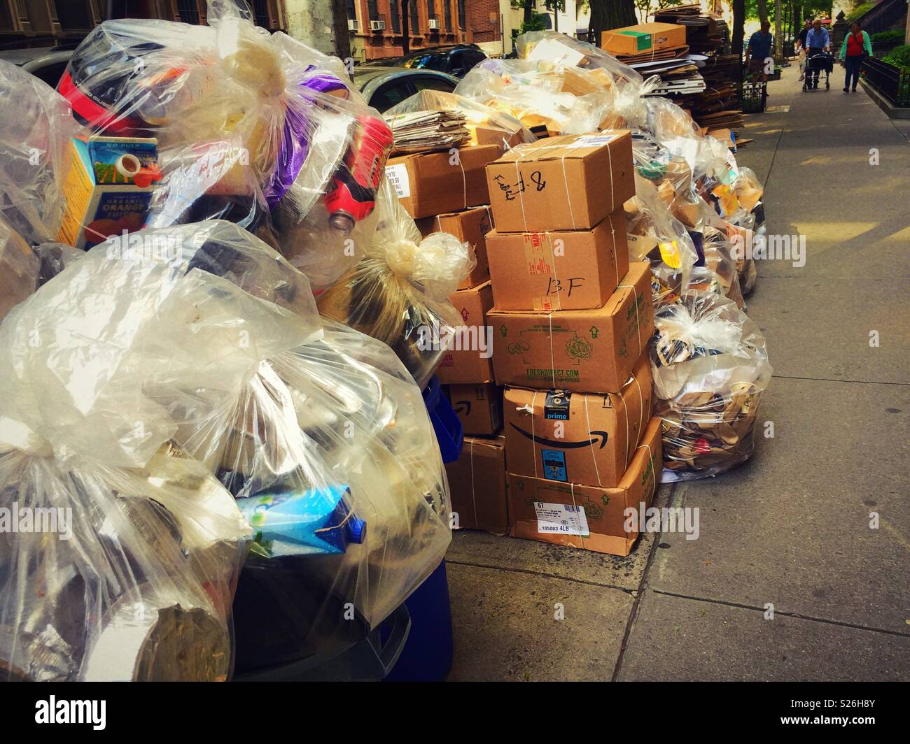 Piles of trash separated by recycling category awaiting pick up by sanitation department, upper West side, NYC, USA - Smartphone Captured Stock Image