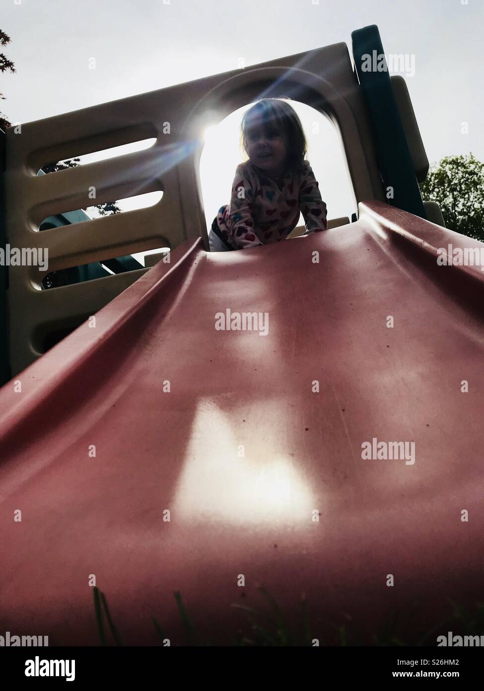 Girl at the top of a slide Stock Photo