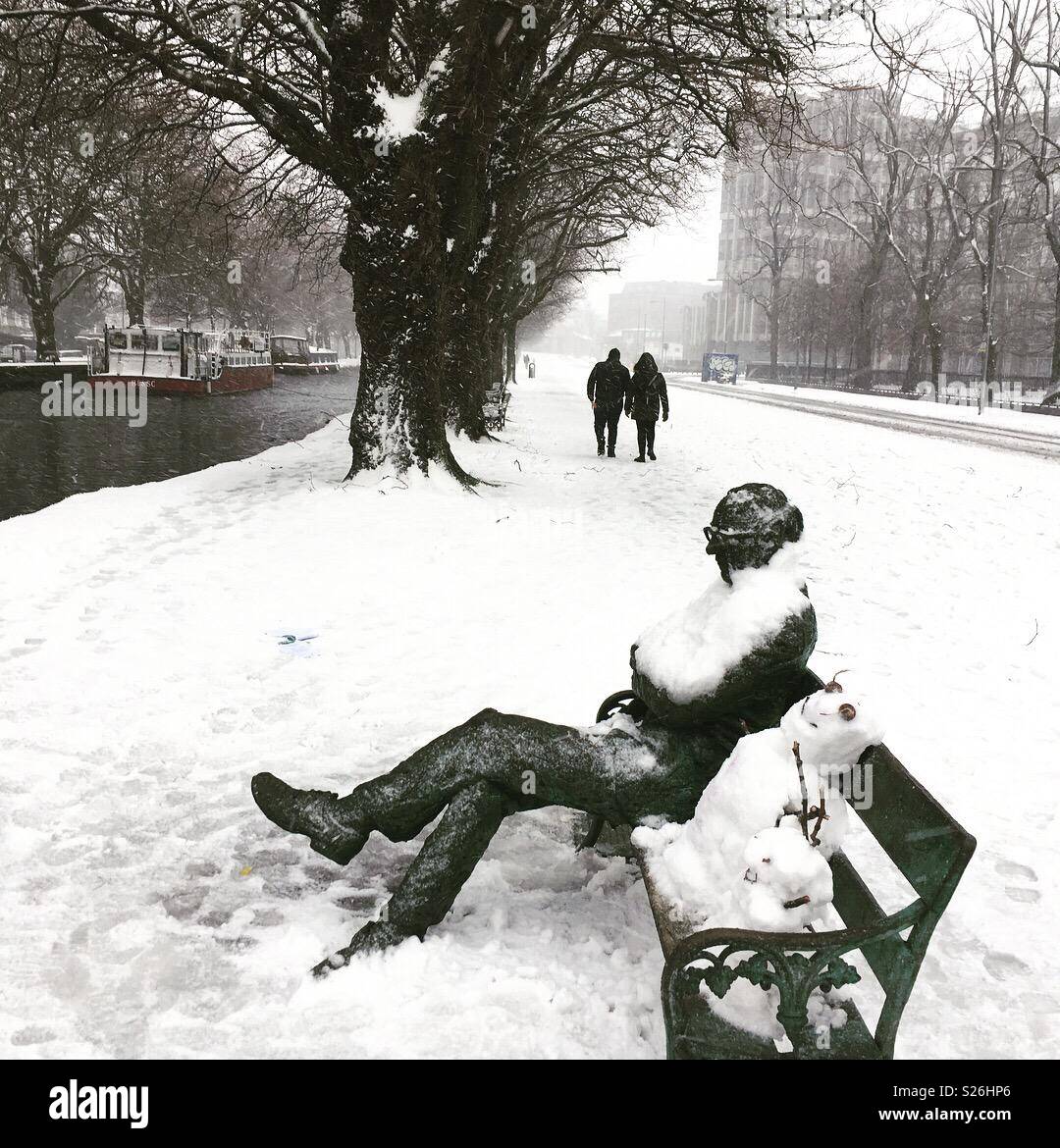 Snowy statue of Dublin poet, Patrick Kavanagh on the bank of the Grand