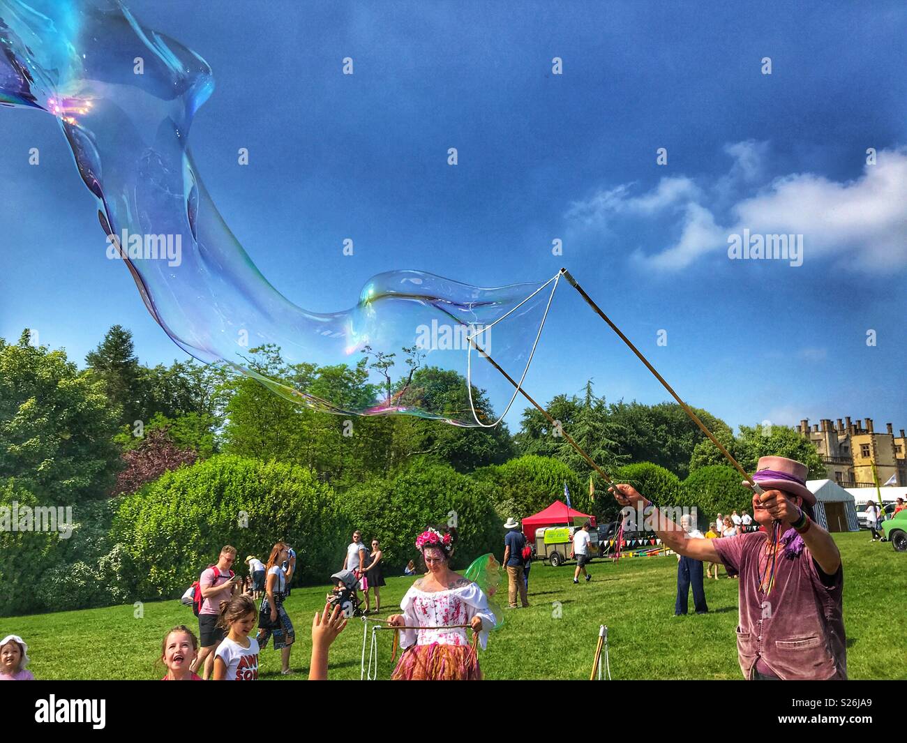 Bubbleman blowing a huge soap bubble, Sherborne Castle Country Fair, Sherborne, Dorset, England - Smartphone Captured Stock Image