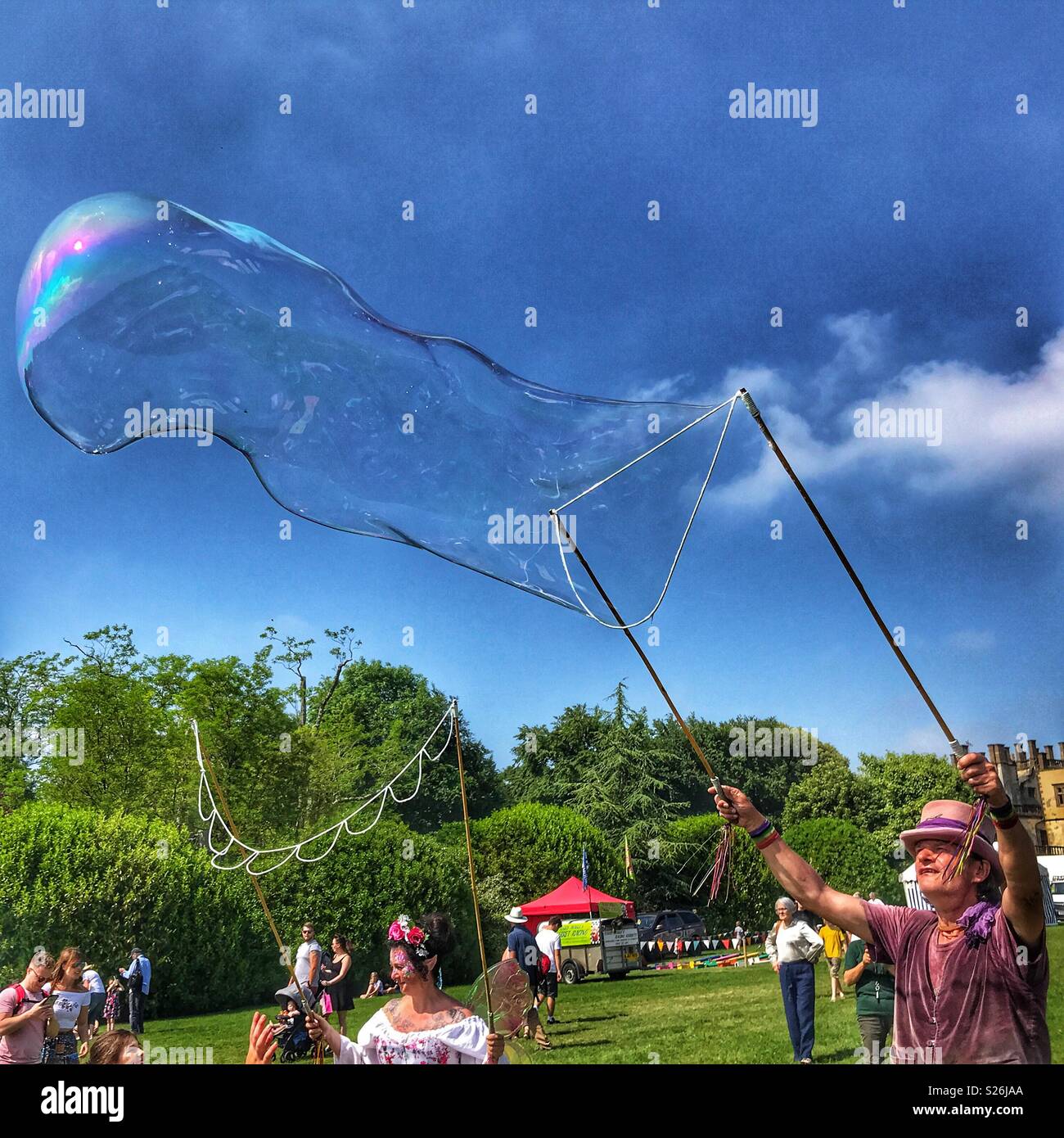 Bubbleman blowing a huge soap bubble, Sherborne Castle Country Fair, Sherborne, Dorset, England - Smartphone Captured Stock Image