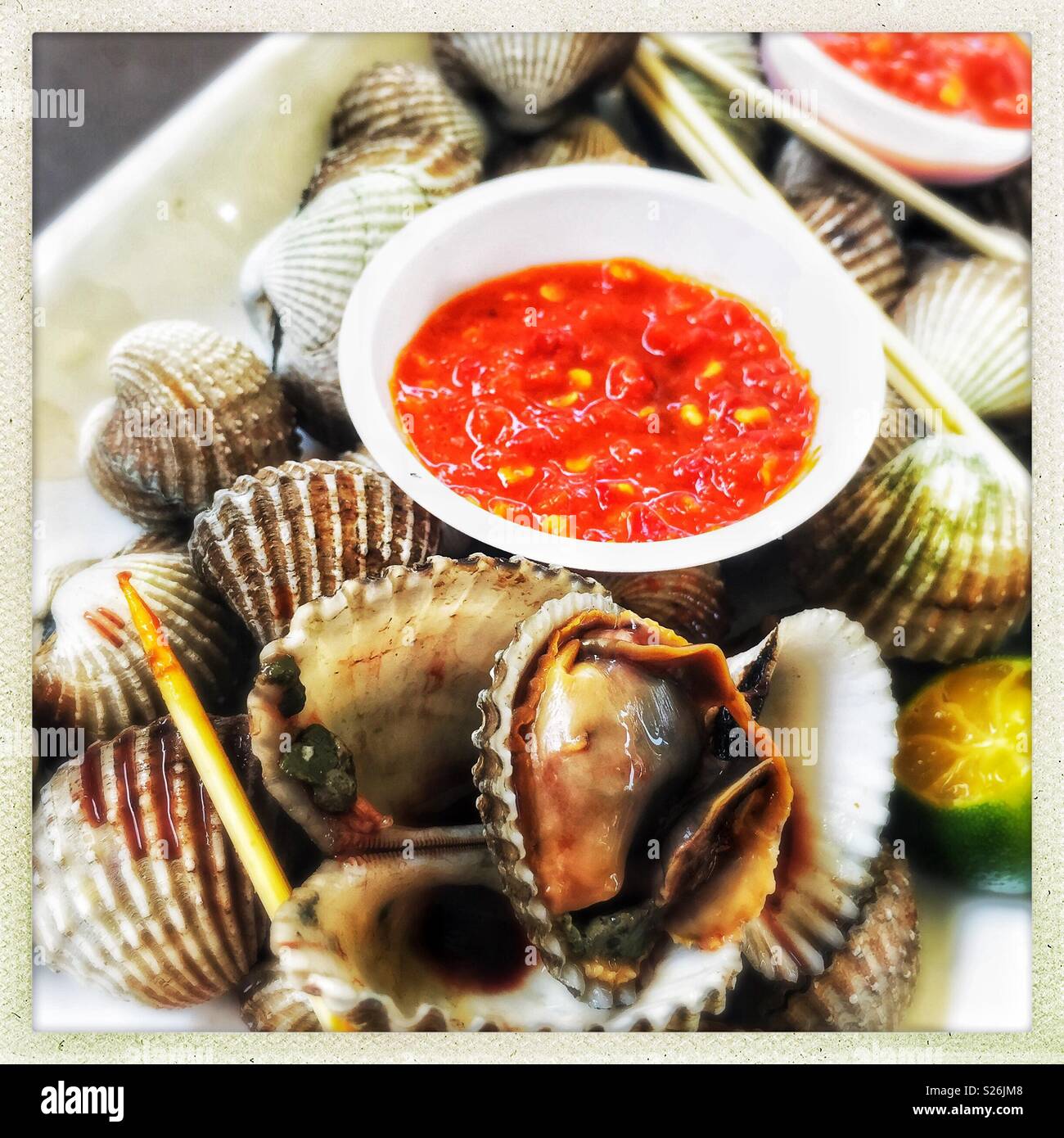 Clams and chilli sauce at East Coast Lagoon Food Village, a hawker food market in Singapore Stock Photo