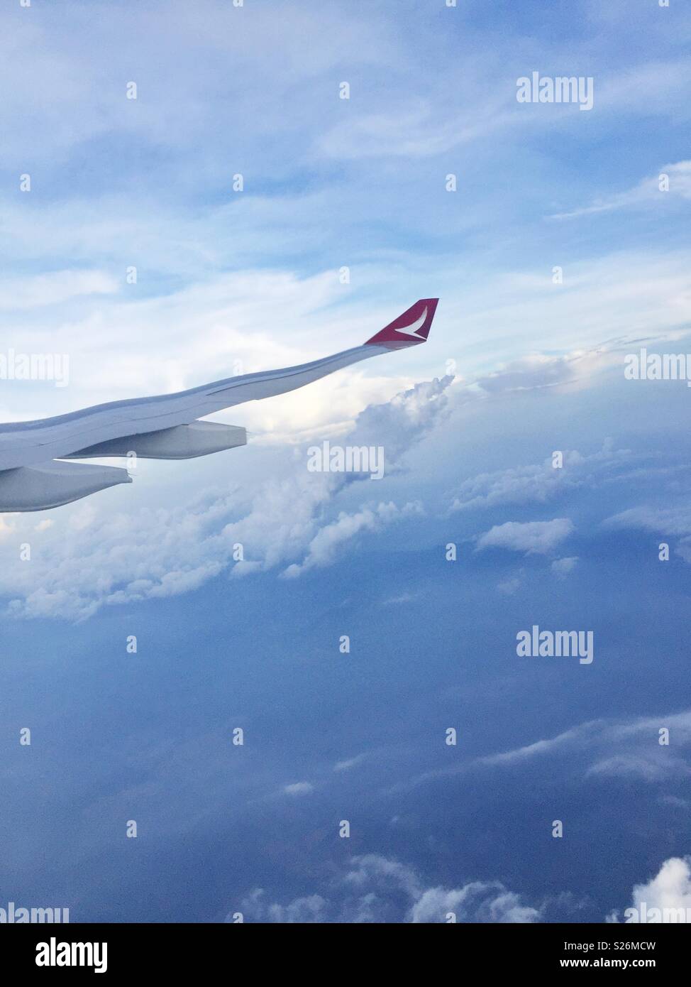 The wing of a Malaysian Airlines passenger jet distorted by the plexiglass of the cabin window - Smartphone Captured Stock Image