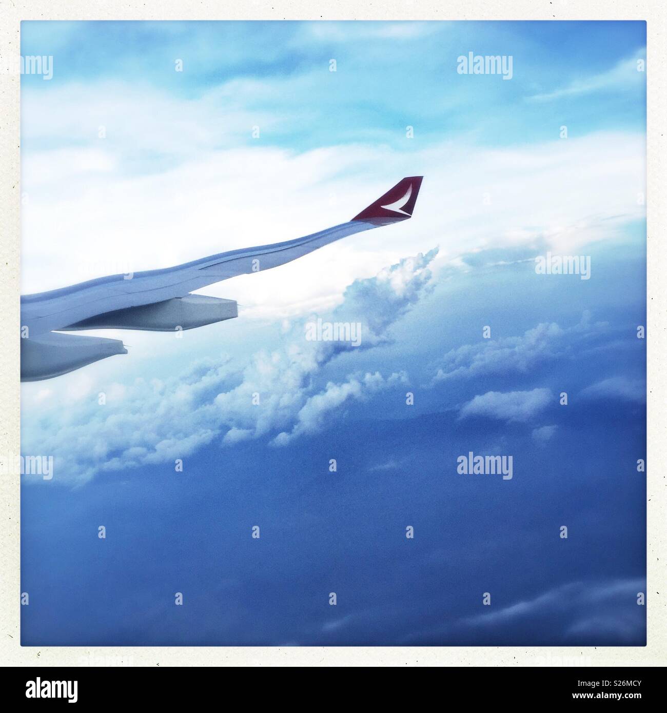 The wing of a Malaysian Airlines passenger jet distorted by the plexiglass of the cabin window - Smartphone Captured Stock Image