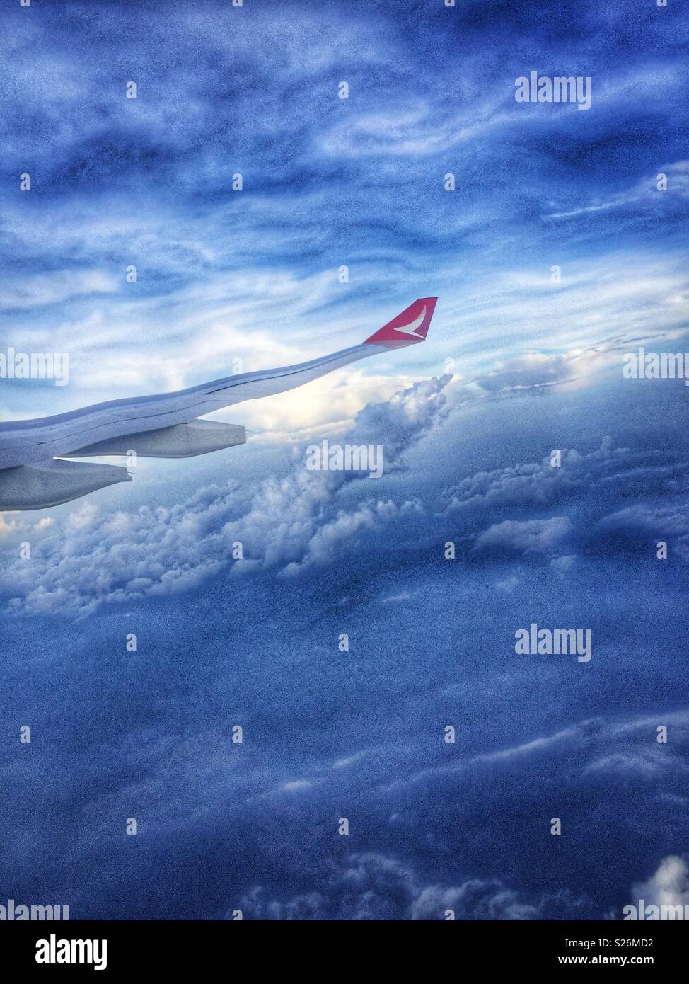 The wing of a Malaysian Airlines passenger jet distorted by the plexiglass of the cabin window - Smartphone Captured Stock Image