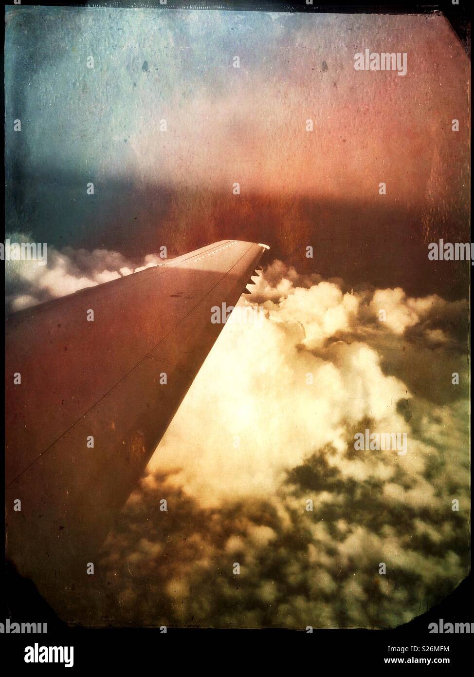 Flying over the clouds. Vertical photograph of an aircraft wing over white clouds. - Smartphone Captured Stock Image