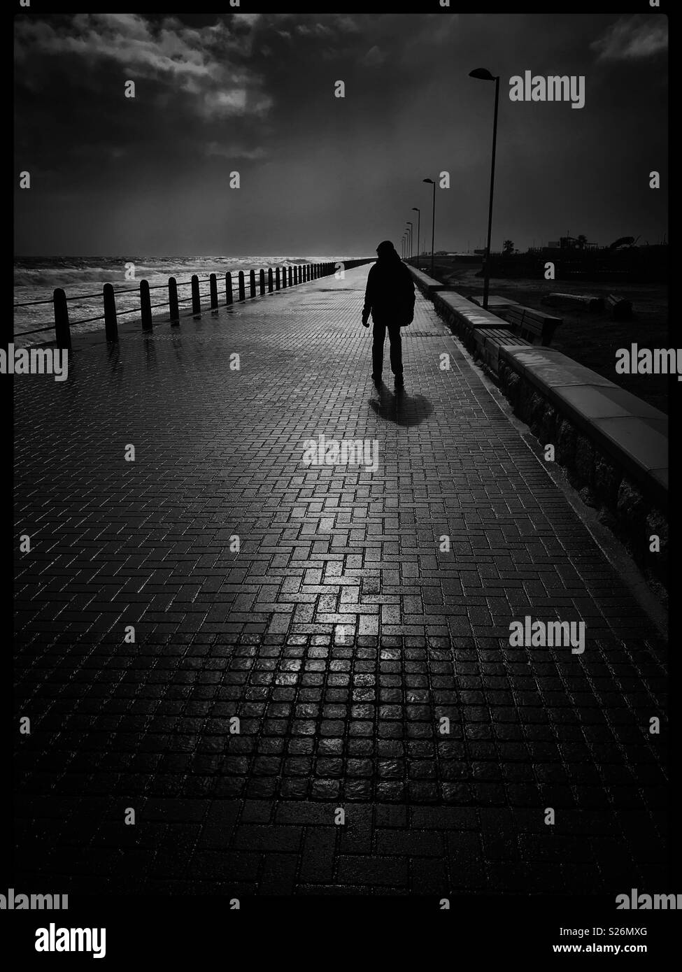 Man walking along Seapoint promenade. - Smartphone Captured Stock Image