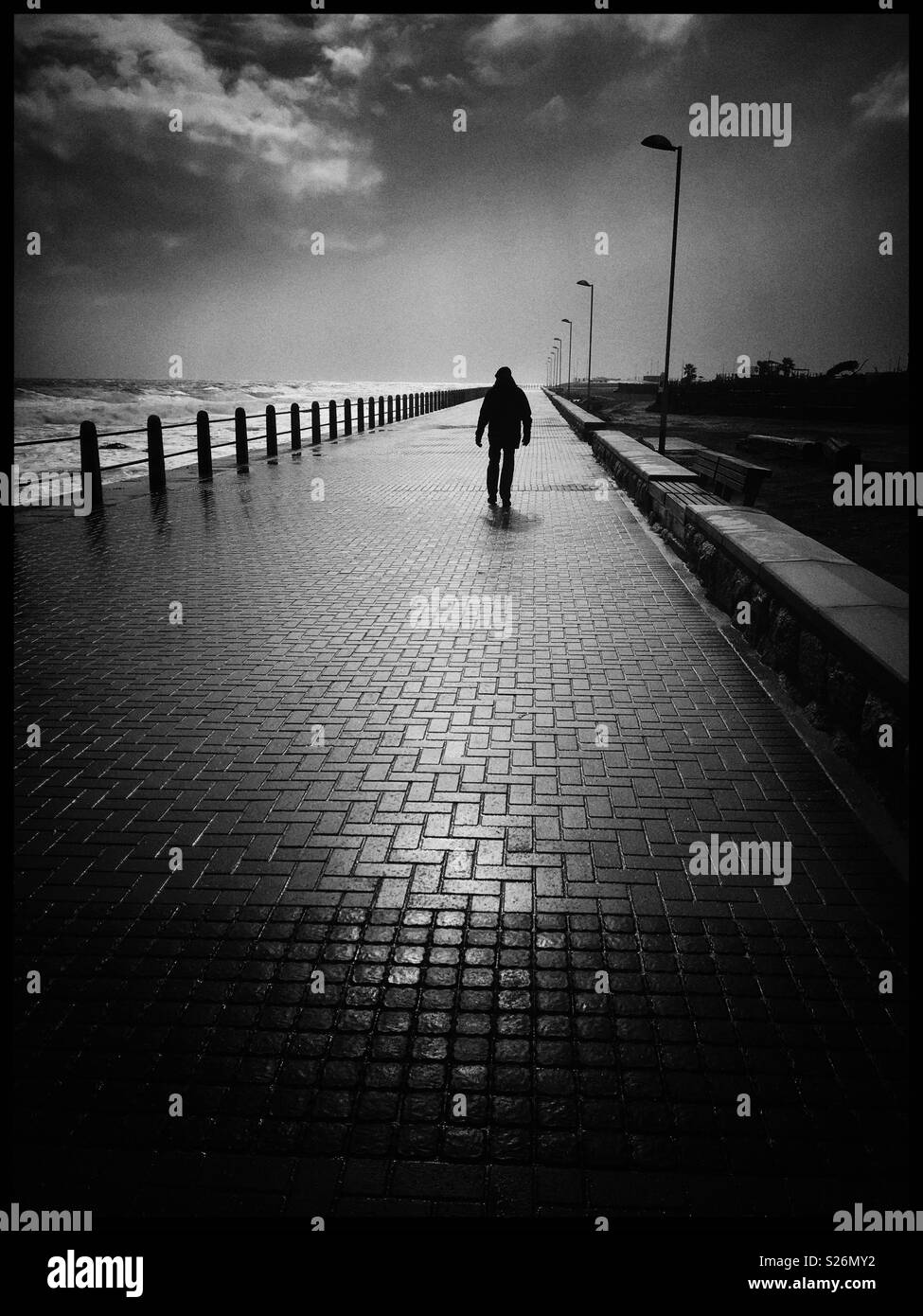 Man walking along Seapoint promenade Stock Photo - Alamy