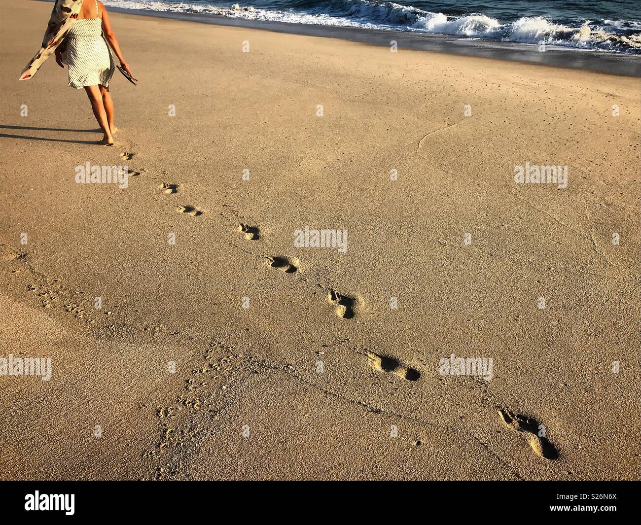 A woman walks in the beach in the Pacific coast in Todos Santos, Baja California, Mexico - Smartphone Captured Stock Image