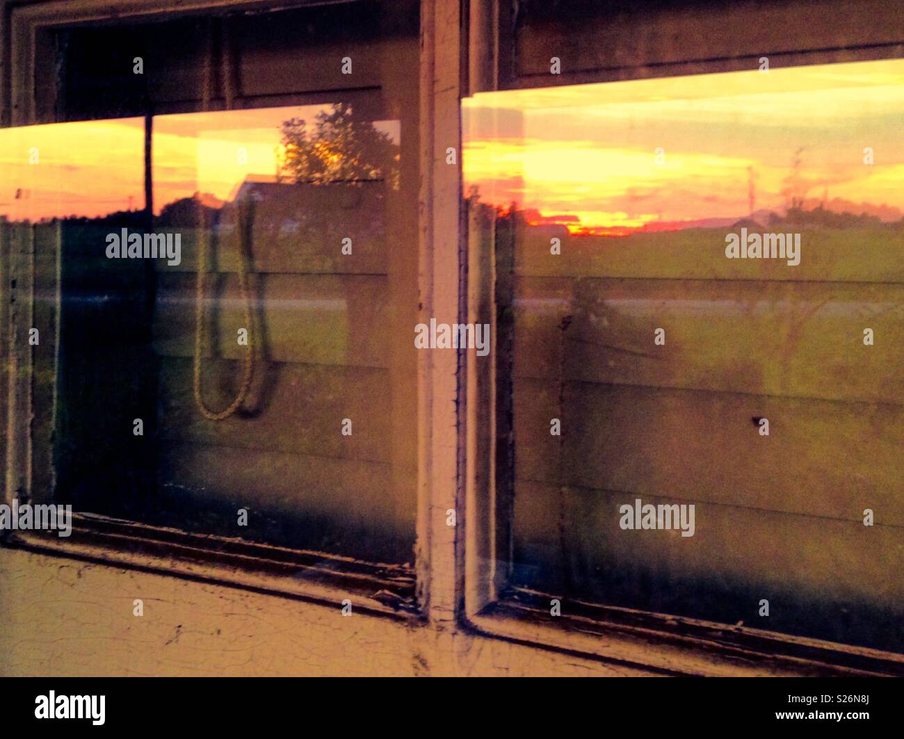 Muntins and window panes reflecting rural sunset - Smartphone Captured Stock Image