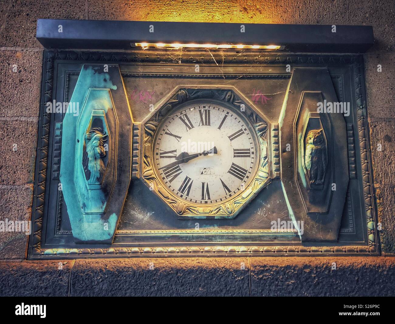 A vintage clock cemented into a stone wall. - Smartphone Captured Stock Image