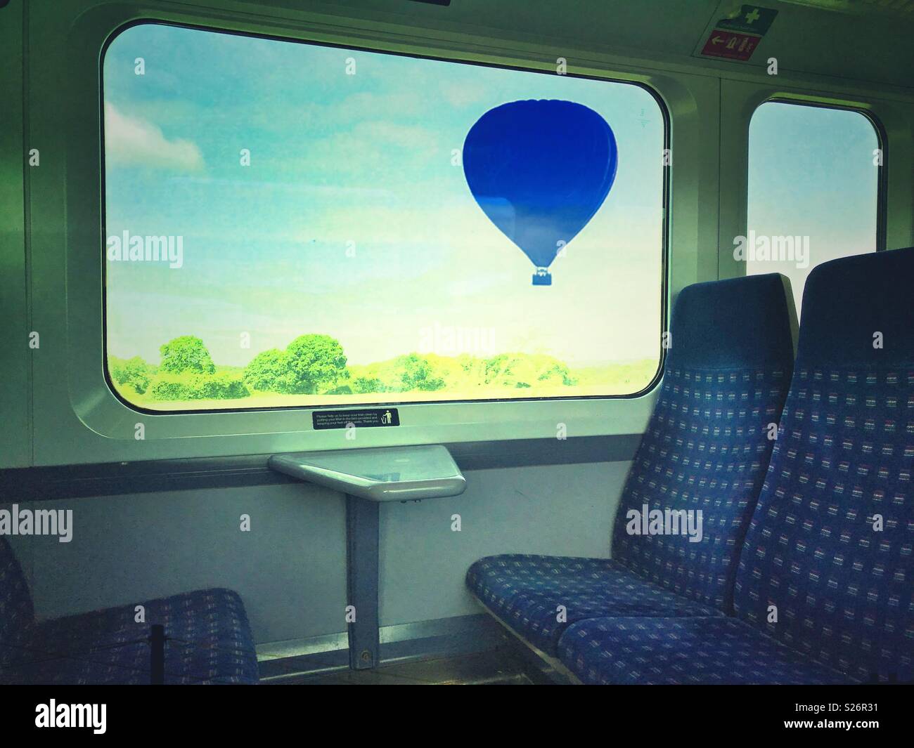 A hot air balloon outside the window of a train - Smartphone Captured Stock Image