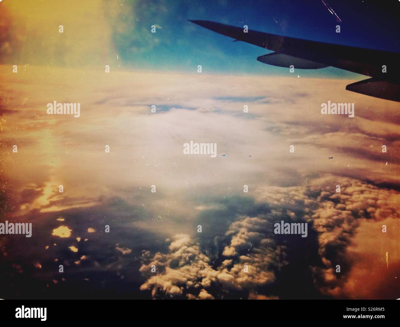 Flying above the clouds. Skyscape with an airplane wing. - Smartphone Captured Stock Image