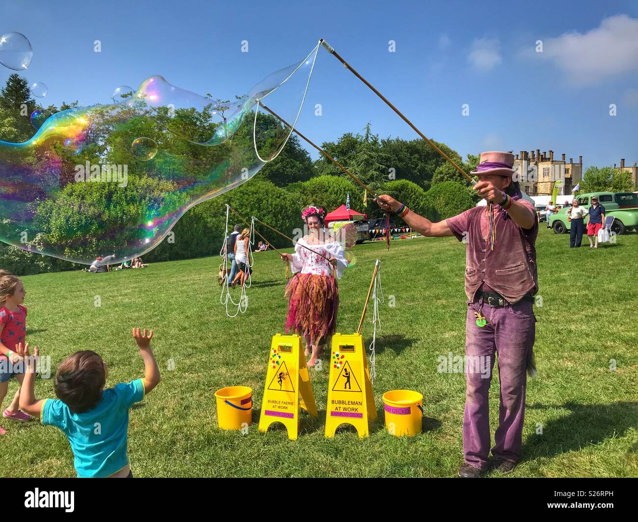 Man and woman creating huge soap bubbles, entertaining children, Sherborne Castle Country Fair, Sherborne, Dorset, England - Smartphone Captured Stock Image