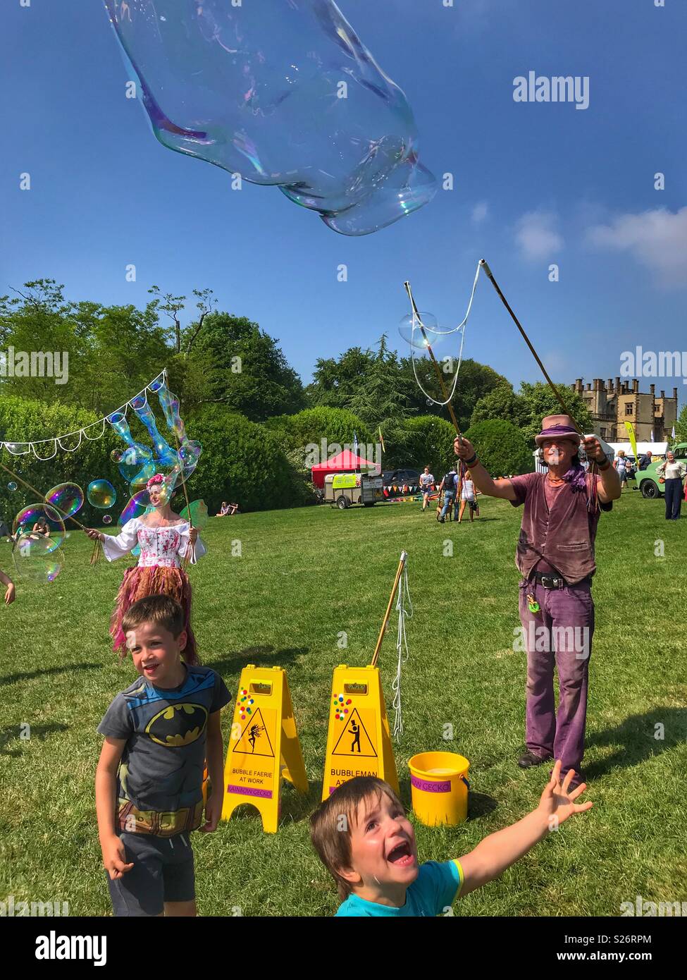 Man and woman creating huge soap bubbles, entertaining children, Sherborne Castle Country Fair, Sherborne, Dorset, England - Smartphone Captured Stock Image