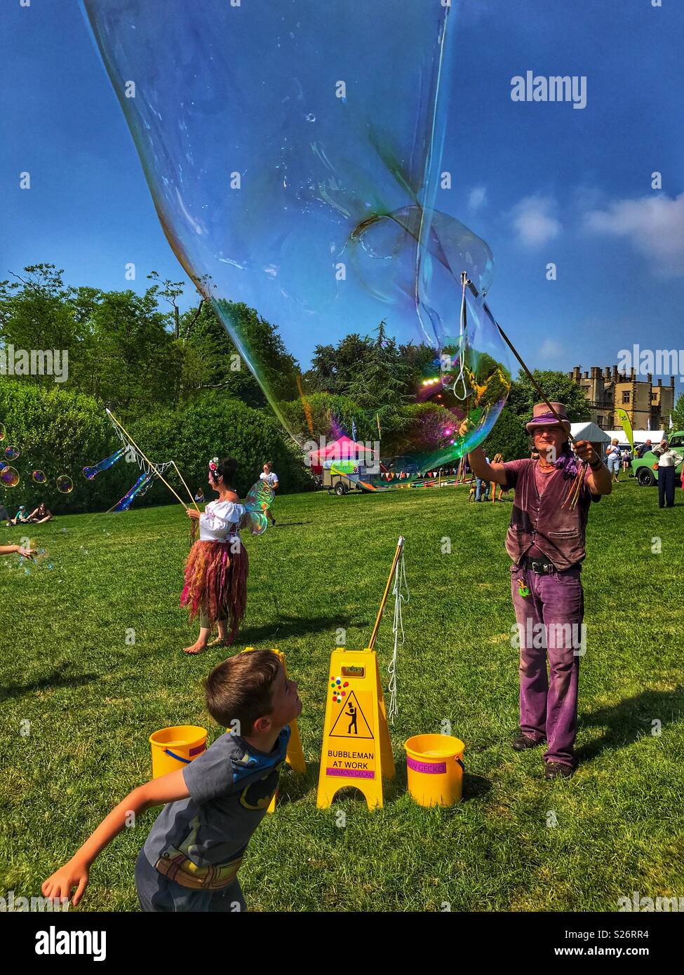 Boy watching huge soap bubbles being created, Sherborne Castle Country Fair, Sherborne, Dorset, England Stock Photo