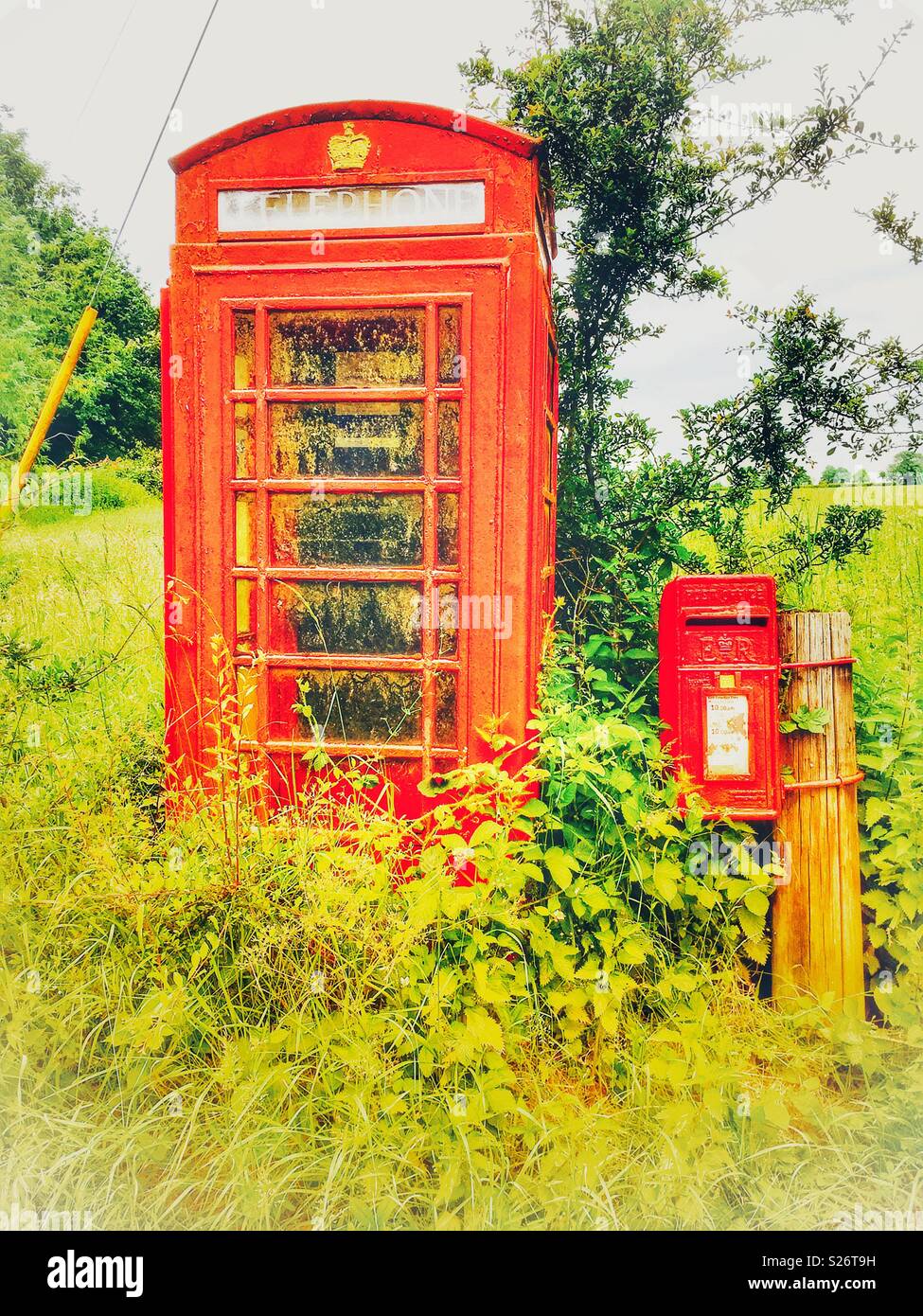 Overgrown telephone box Stock Photo