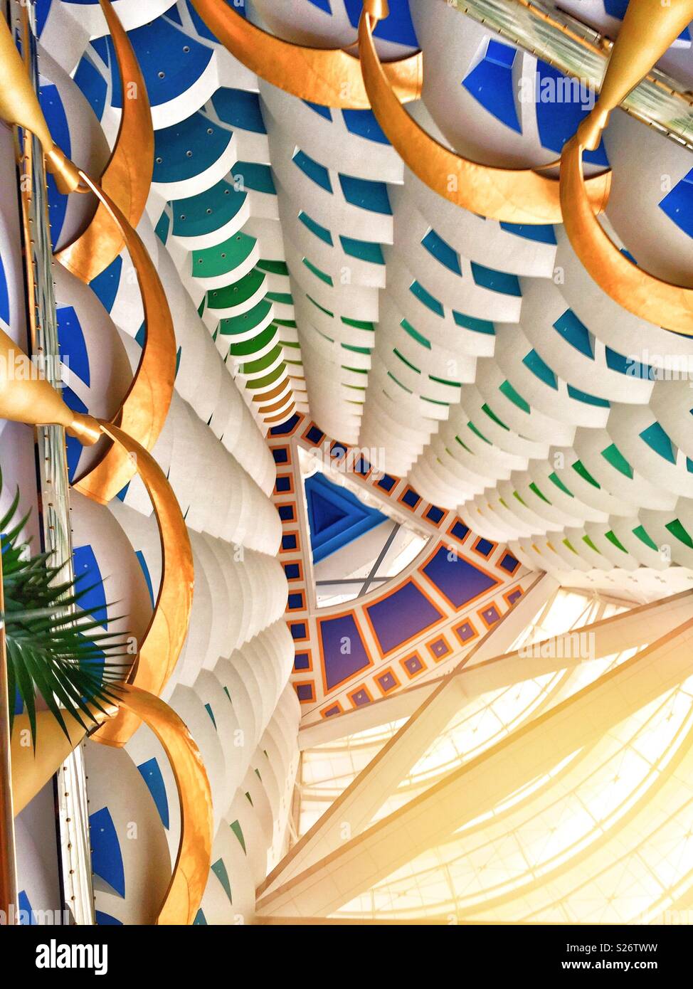 View from inside the Burj Al Arab, Dubai. The colourful balconies and ceiling provide an abstract backdrop,with the bright sun streaming into the atrium. Stock Photo