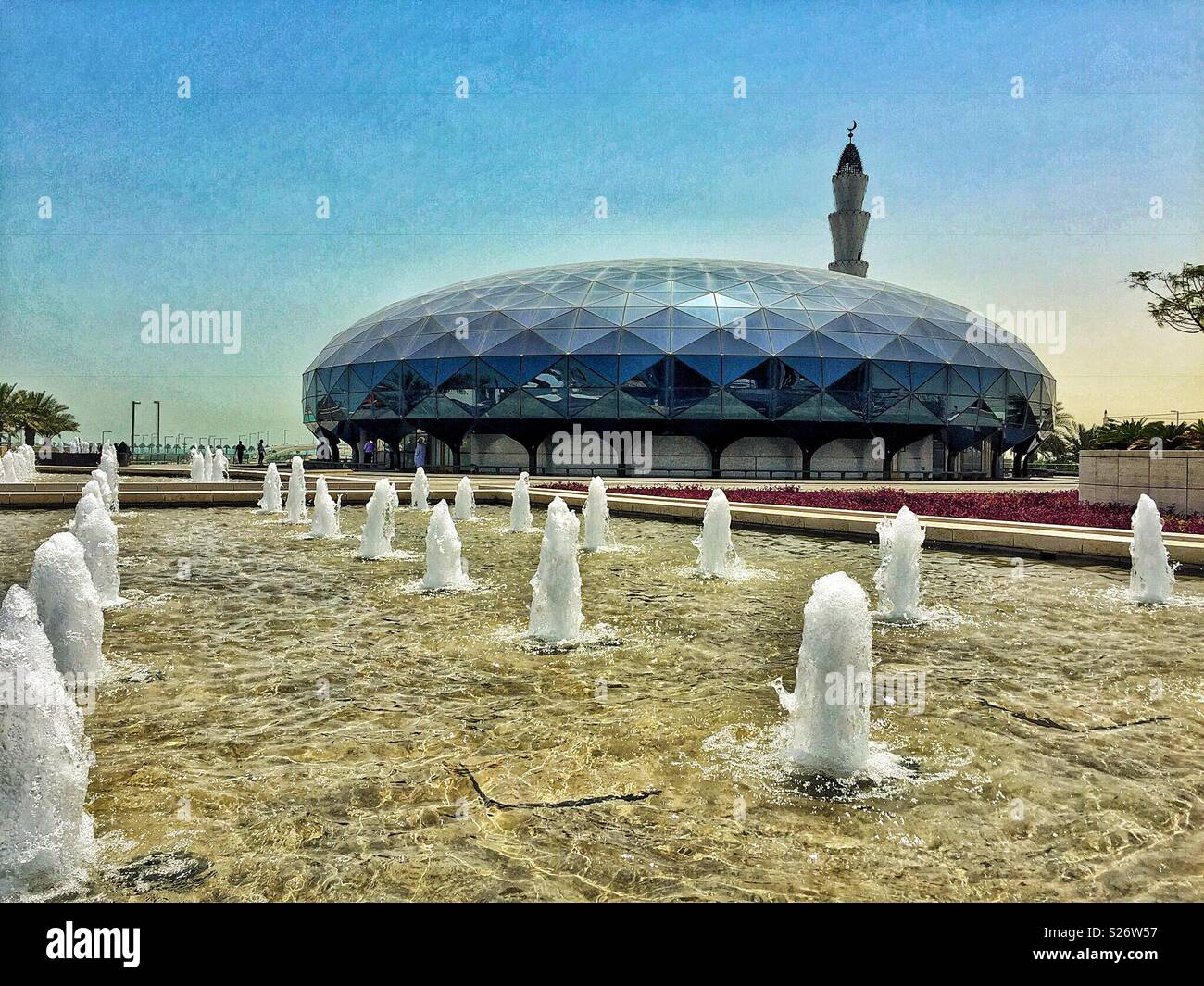 Cooling fountains surround the the stylish and modern Mosque at Hamad International Airport, Doha, Qatar, providing a welcome relief from the extreme summer heat - Smartphone Captured Stock Image