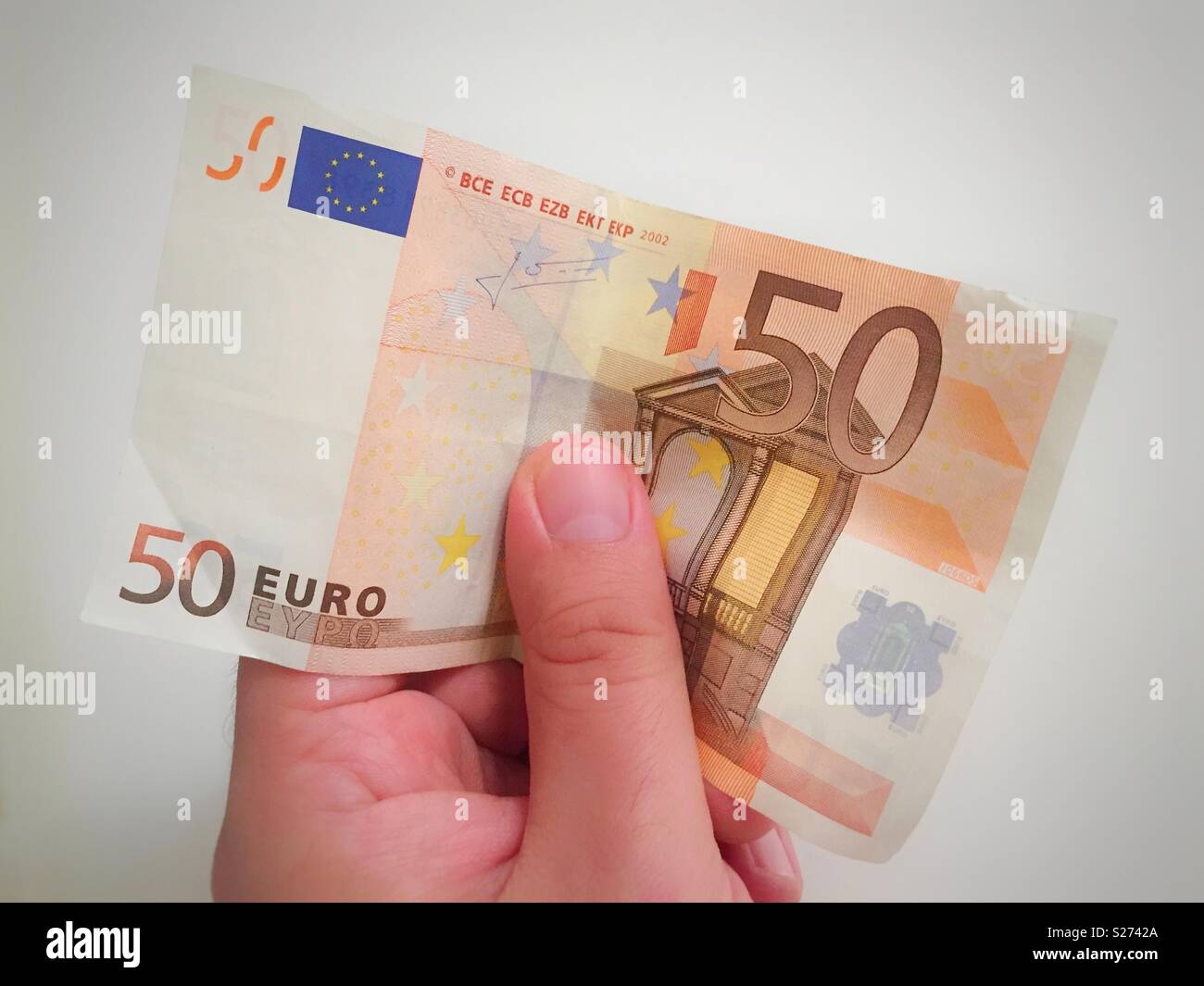 Male hand holding a 50 euro banknote - Smartphone Captured Stock Image