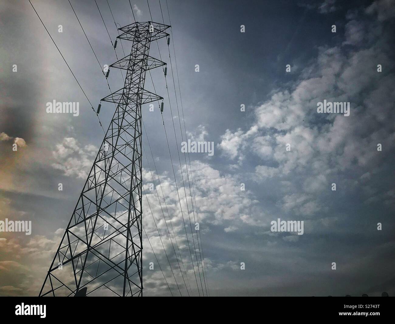Torre de electricidad en zona urbana y de fondo cielo nublado con contraste Stock Photo