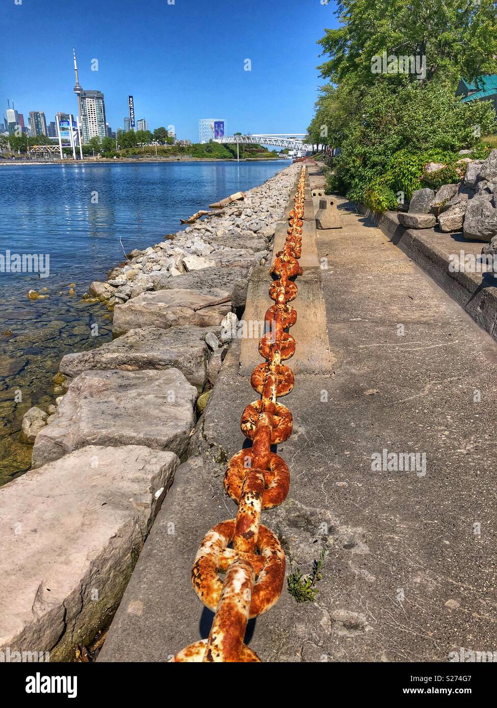 A straight line of an old rusted chain link on the shores of Lake Ontario in Toronto. - Smartphone Captured Stock Image