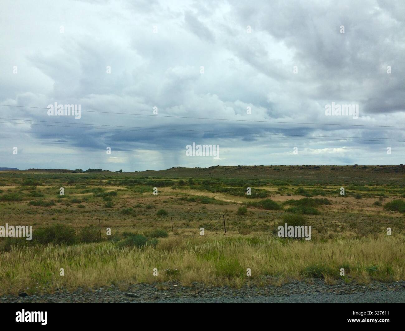 Landscape view onto semi desert vegetation in Karoo National Park, South Africa on an overcast dull Autumn day with rain clouds in the distance Stock Photo
