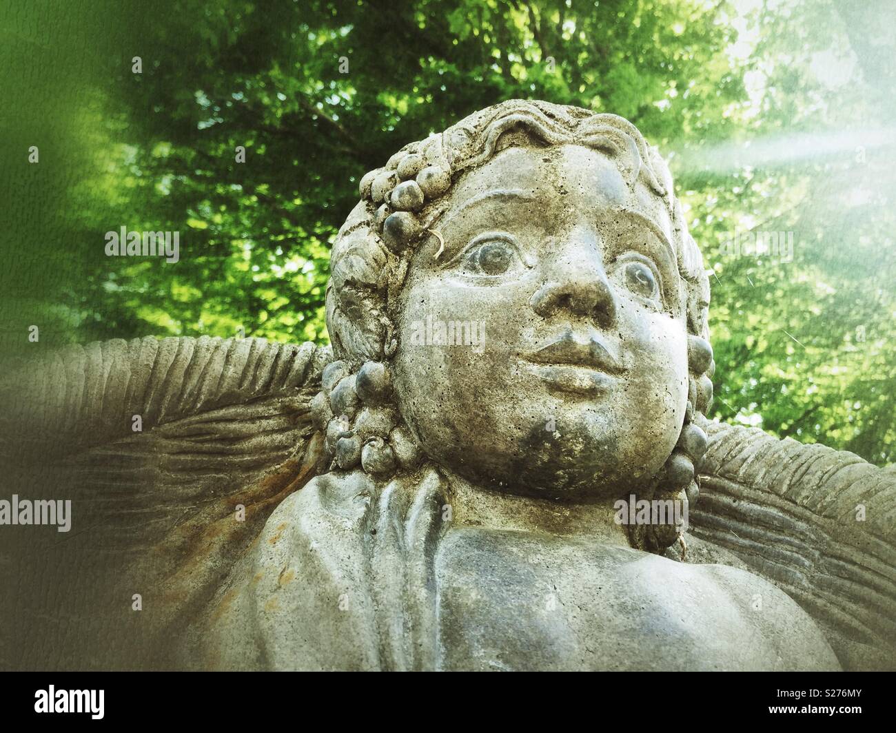 Looking up at stone angel in green garden - Smartphone Captured Stock Image
