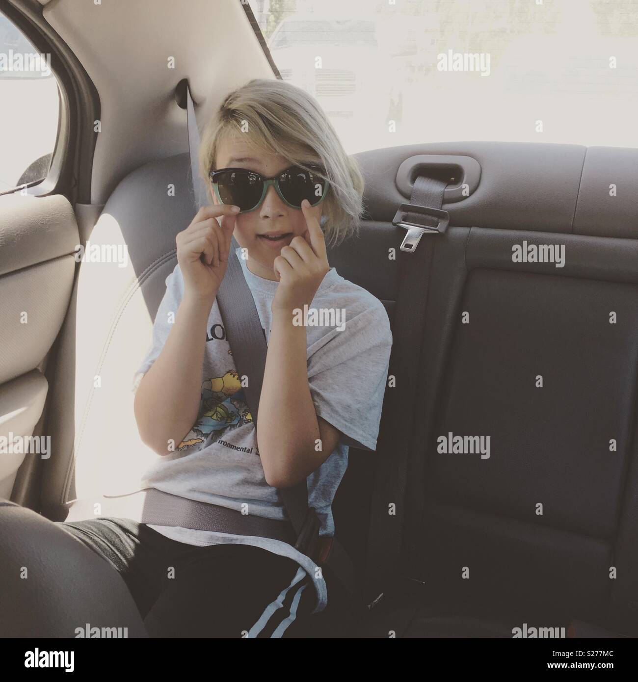 A child riding in the backseat of a car. Stock Photo