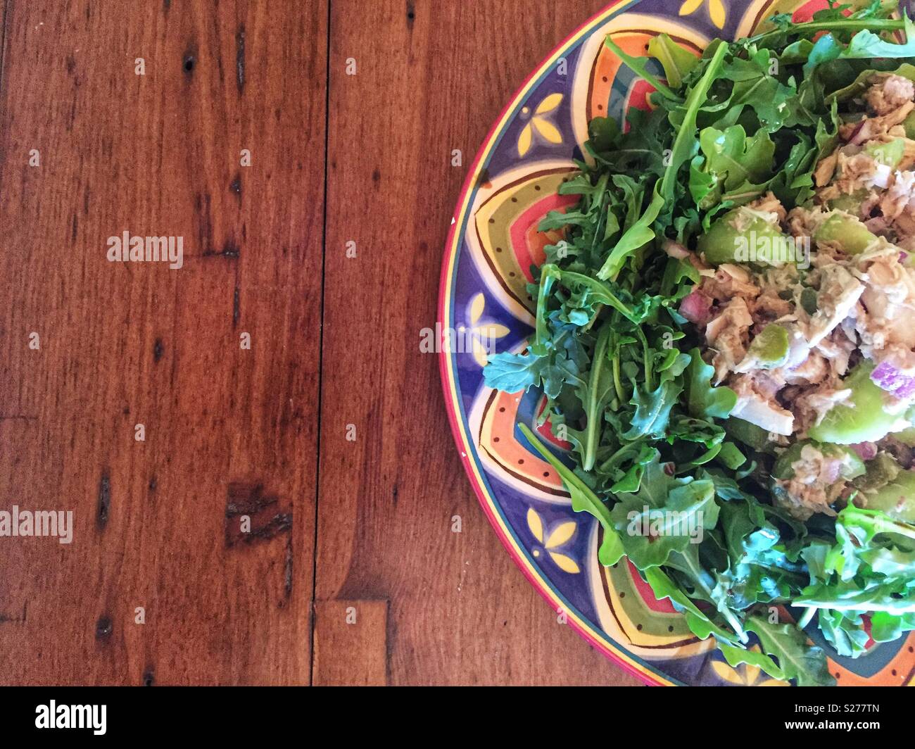 Healthy tuna salad lunch on colourful plate and wood table - Smartphone Captured Stock Image