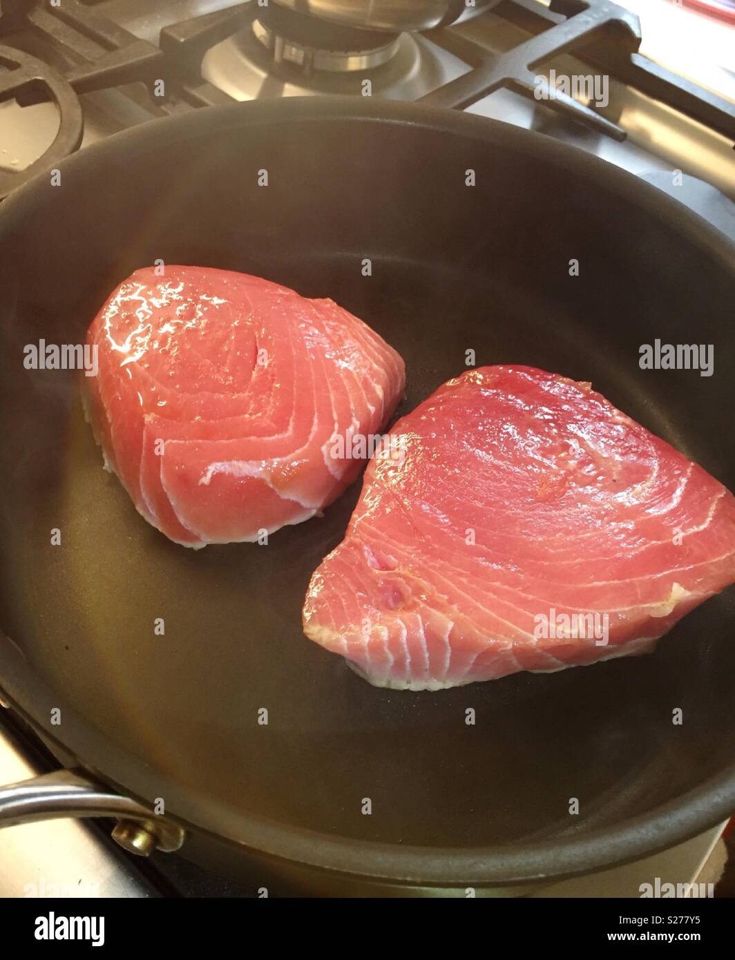 Slices of fresh tuna searing in a hot skillet, USAA Stock Photo