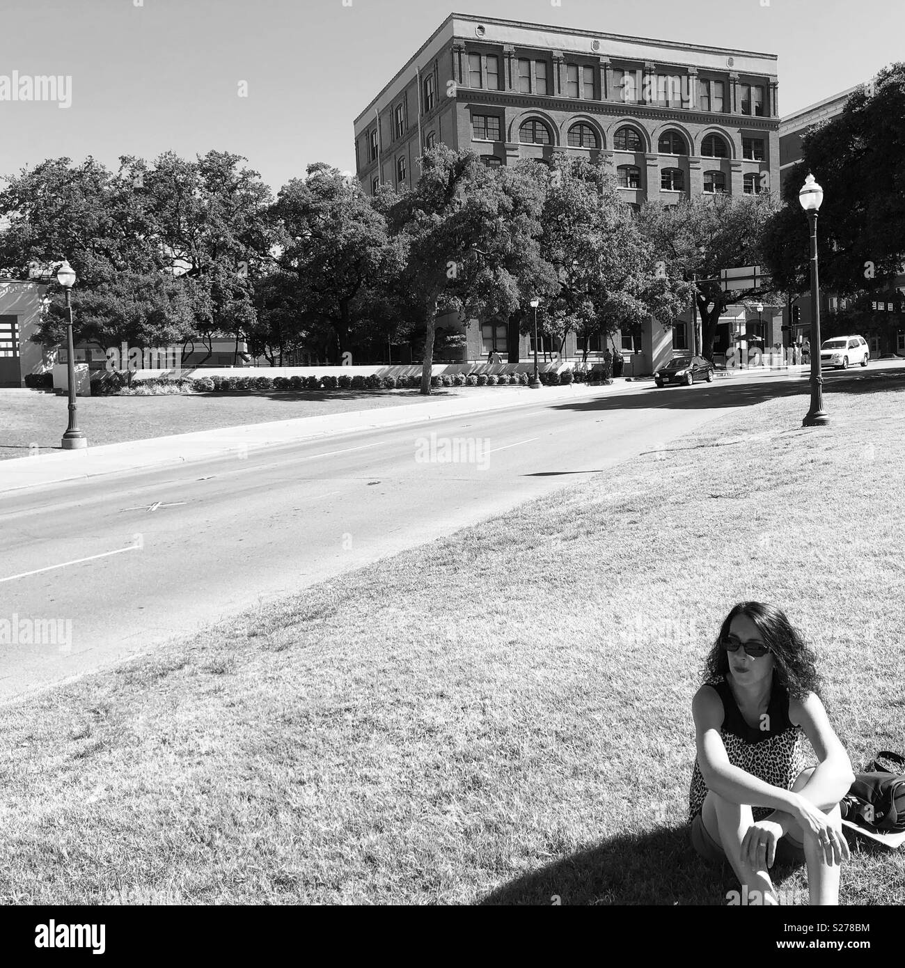The ‘Grassy Knoll’ at Dealey Plaza, Dallas, Texas where you can see the ‘X’ in the road where Kennedy was assassinated and the Book Depository building in the background Stock Photo