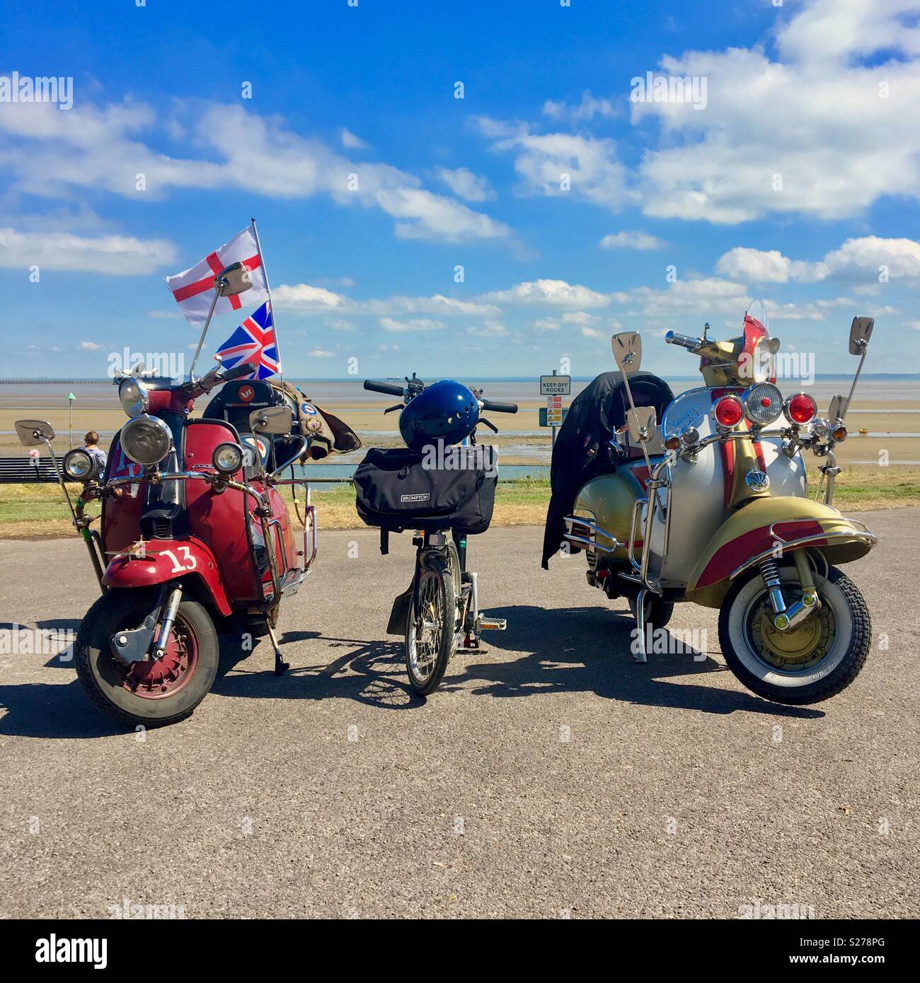 A Brompton bicycle parked between two vintage motor scooters at the seaside  Stock Photo - Alamy